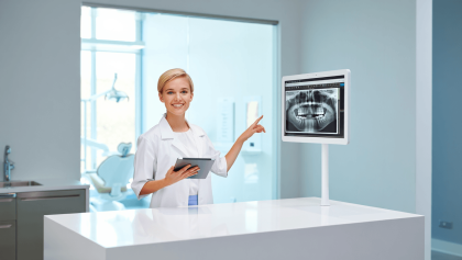 output:  Moderner Krankenhausflur mit Empfang und Pflanzen.
