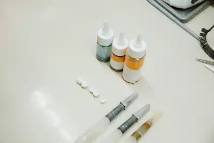 Zahnimplantat und Keramikkrone nebeneinander mit klinischen Instrumenten