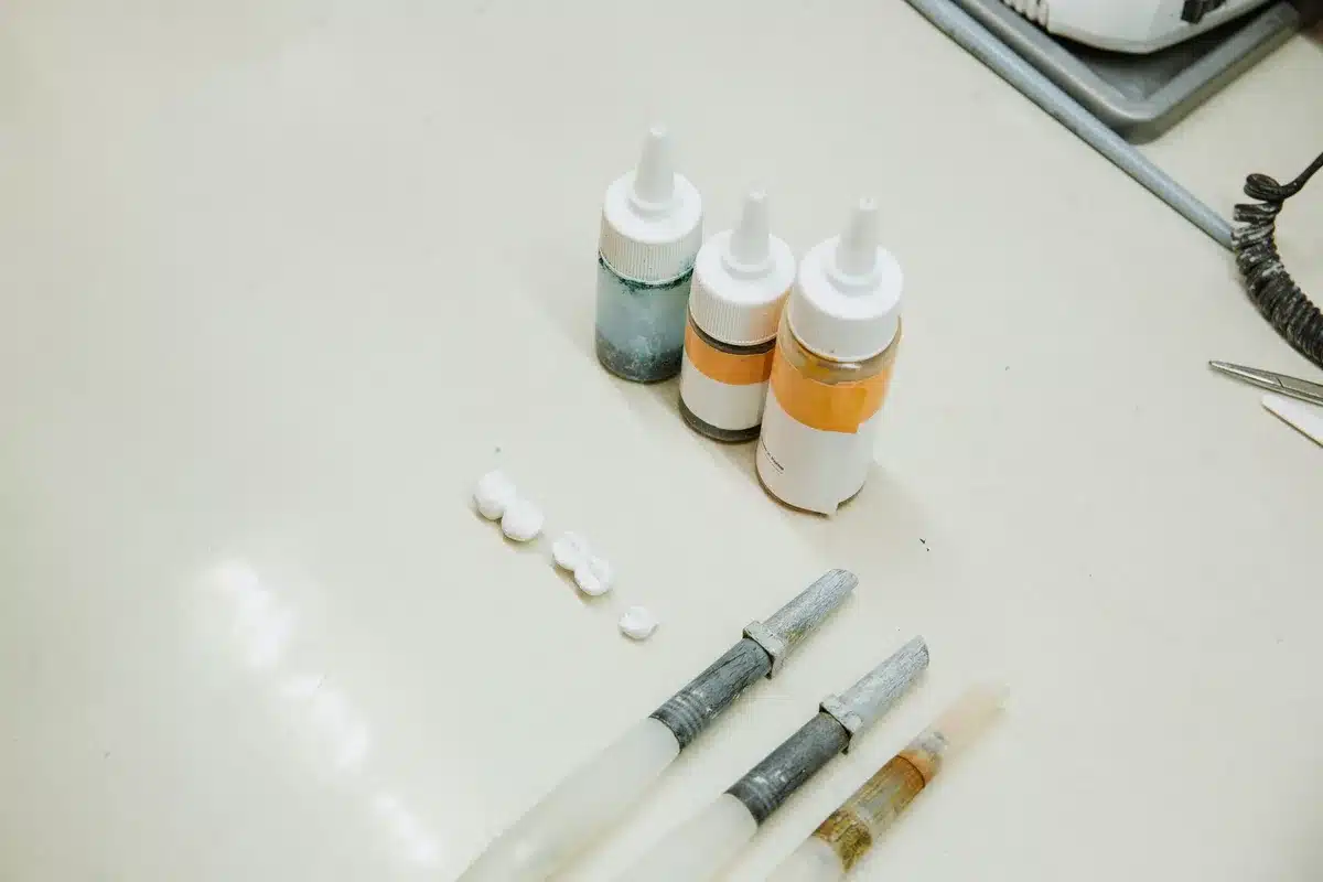 Zahnimplantat und Keramikkrone nebeneinander mit klinischen Instrumenten