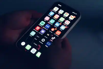 Hände scrollen durch eine mobile Nachrichtenseite mit strukturierten Artikelkarten und Navigationselementen