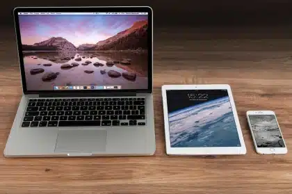 Redaktionsschreibtisch mit Laptop, Ausdruck eines Inhaltsverzeichnisses und Smartphone mit ausgeklapptem Menü