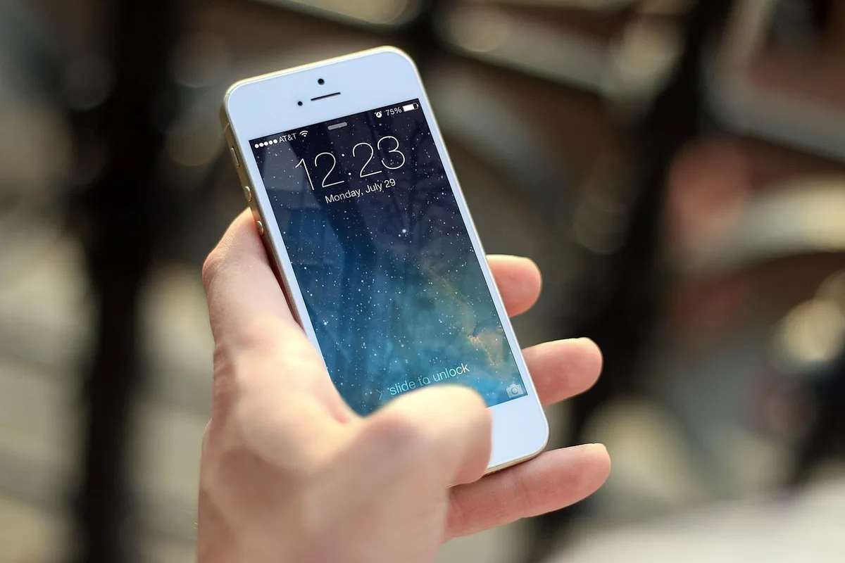 Person testet Website auf Smartphone unter verschiedenen Netzwerkbedingungen