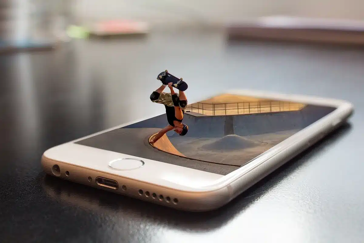 Entwickler testet mobile Website mit Smartphone und Laptop