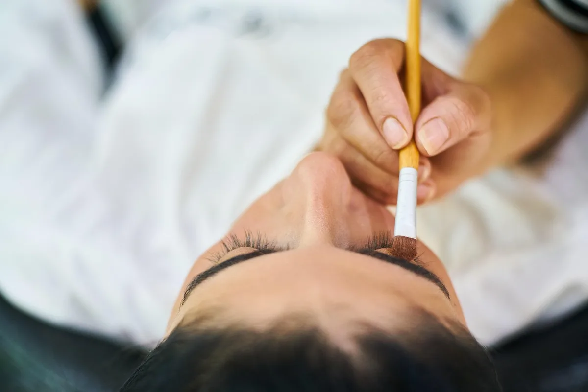 Pflegekraft und Bewohnerin mit Oberkieferprothese und Prothesenbürste