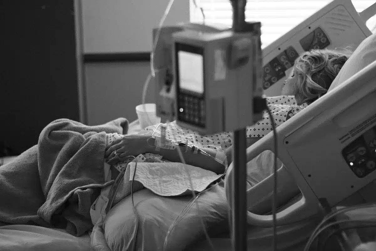 Hände halten Quittung und elektronische Gesundheitskarte an einem Empfangstresen