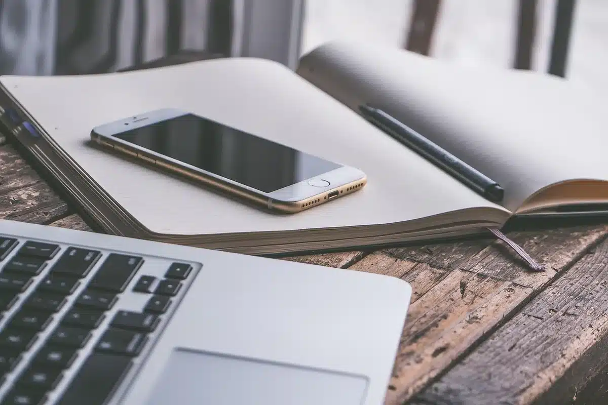 Silhouette einer Person am Schreibtisch, die einen Artikel auf dem Smartphone liest