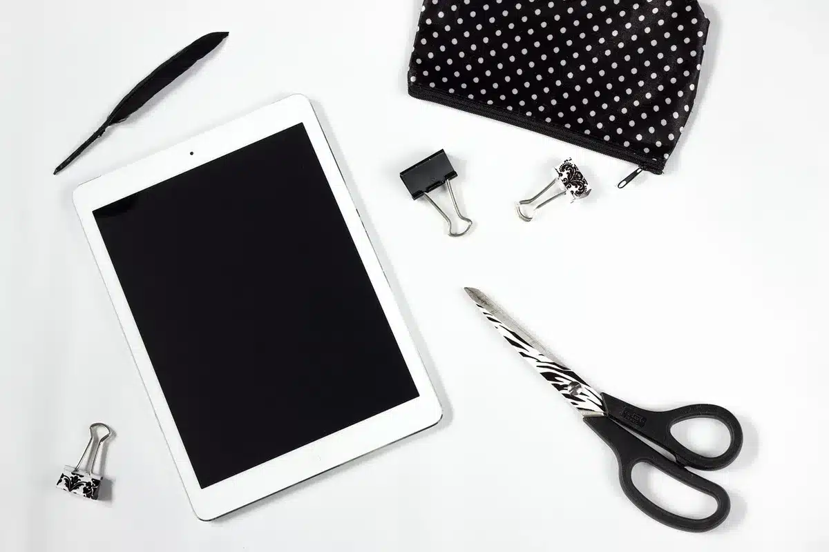 Hände halten Tablet mit Innovationsdaten und Diagrammen in modernem Büro