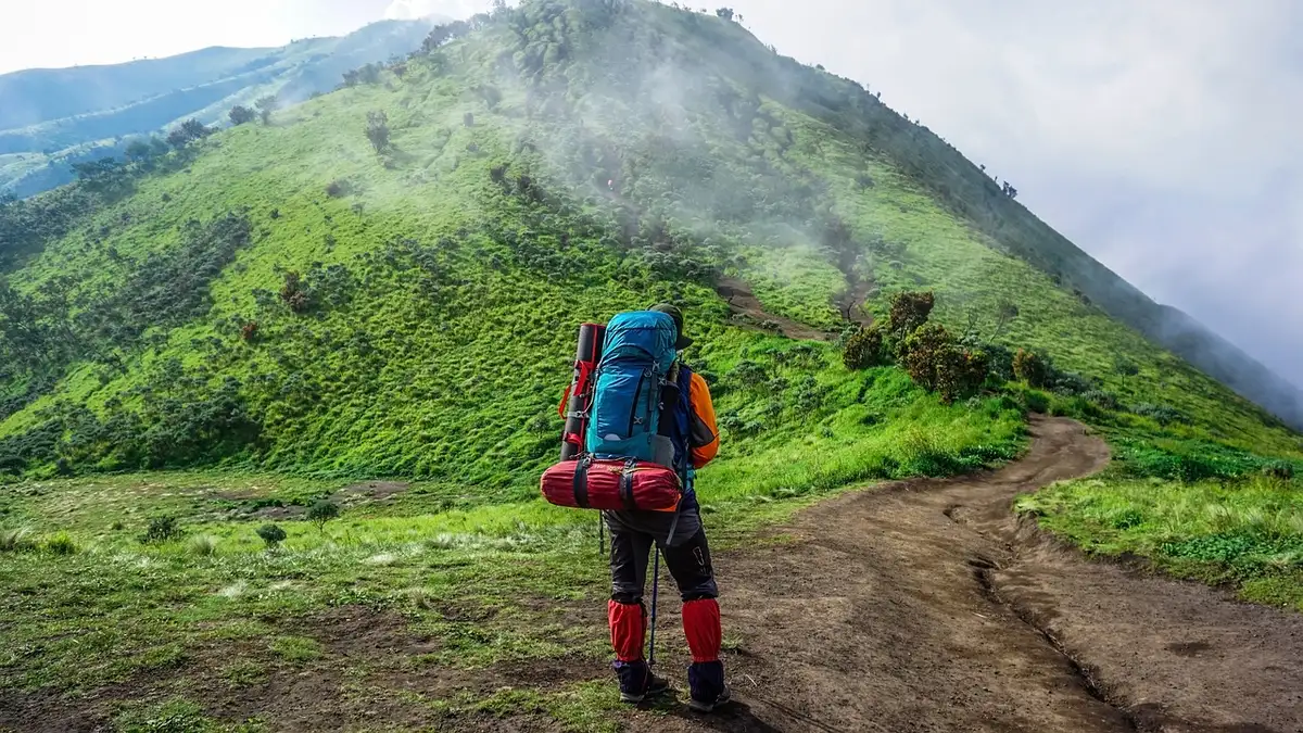 Wanderer auf einem Bergweg nahe einem Hotelgebäude