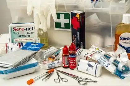 Gloved hands greifen in einen organisierten Notfallkoffer in einer Praxisumgebung